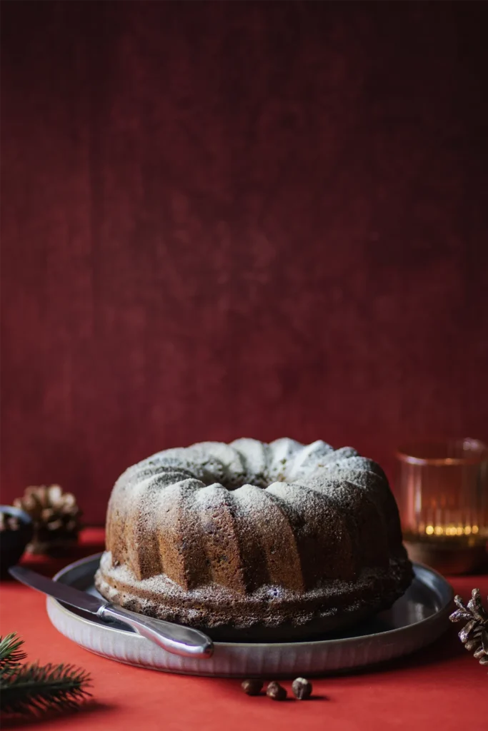 Fotografiert von David Steiner für Kochbackwelt: Nahaufnahme eines weihnachtlichen Gugelhupfs mit Glasur und festlicher Dekoration.