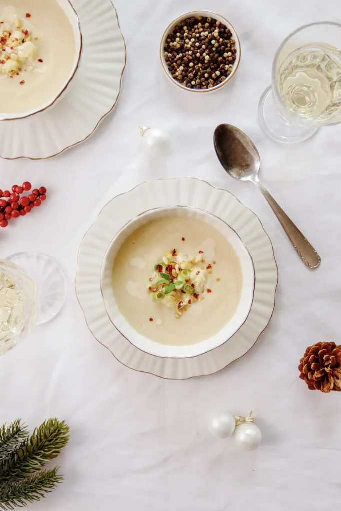 Karfiolcreme-Suppe mit Pinienkern-Topping, fotografiert von David Steiner für Kochbackwelt – cremige Suppe perfekt angerichtet in winterlicher Atmosphäre.