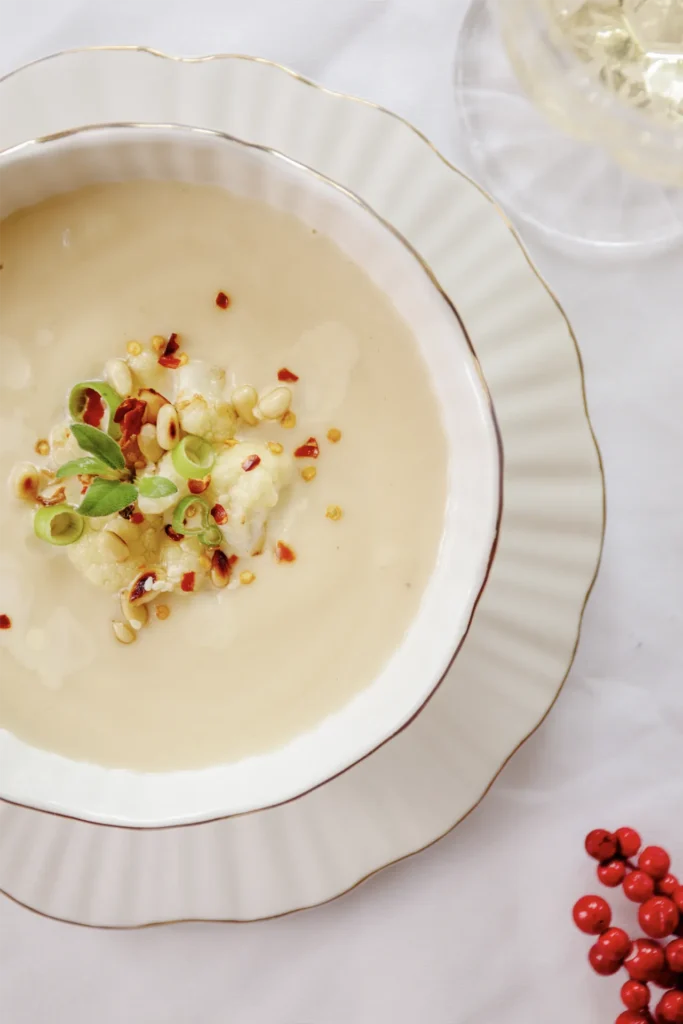 Karfiolcreme-Suppe mit Pinienkern-Topping, fotografiert von David Steiner für Kochbackwelt – cremige Suppe perfekt angerichtet in winterlicher Atmosphäre.