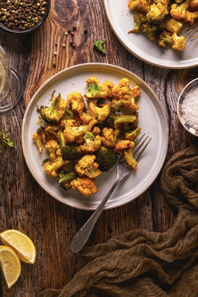 Knuspriges Karfiol-Brokkoli-Popcorn, veganer Snack, gesund und lecker, perfekt für den Veganuary, auf einem Backblech angerichtet, goldbraun gebacken.