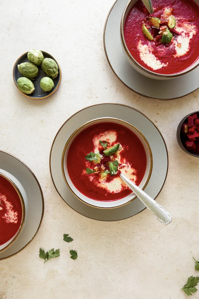 Leuchtend rote Rote-Bete-Suppe in einer Schale, garniert mit frischen Kräutern und einem Klecks Joghurt – ein farbenfroher und gesunder Wintergenuss.