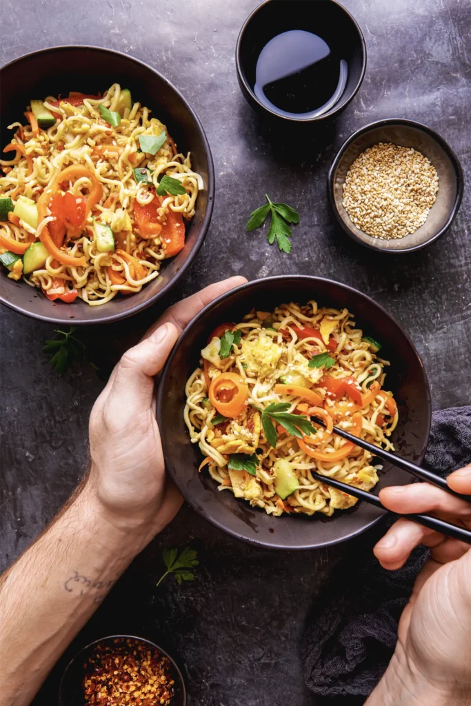 Asia-Nudeln mit knackigem Gemüse, Sojasauce und Sesam in einer Wok-Pfanne – schneller Genuss voller Geschmack und bunter Aromen.