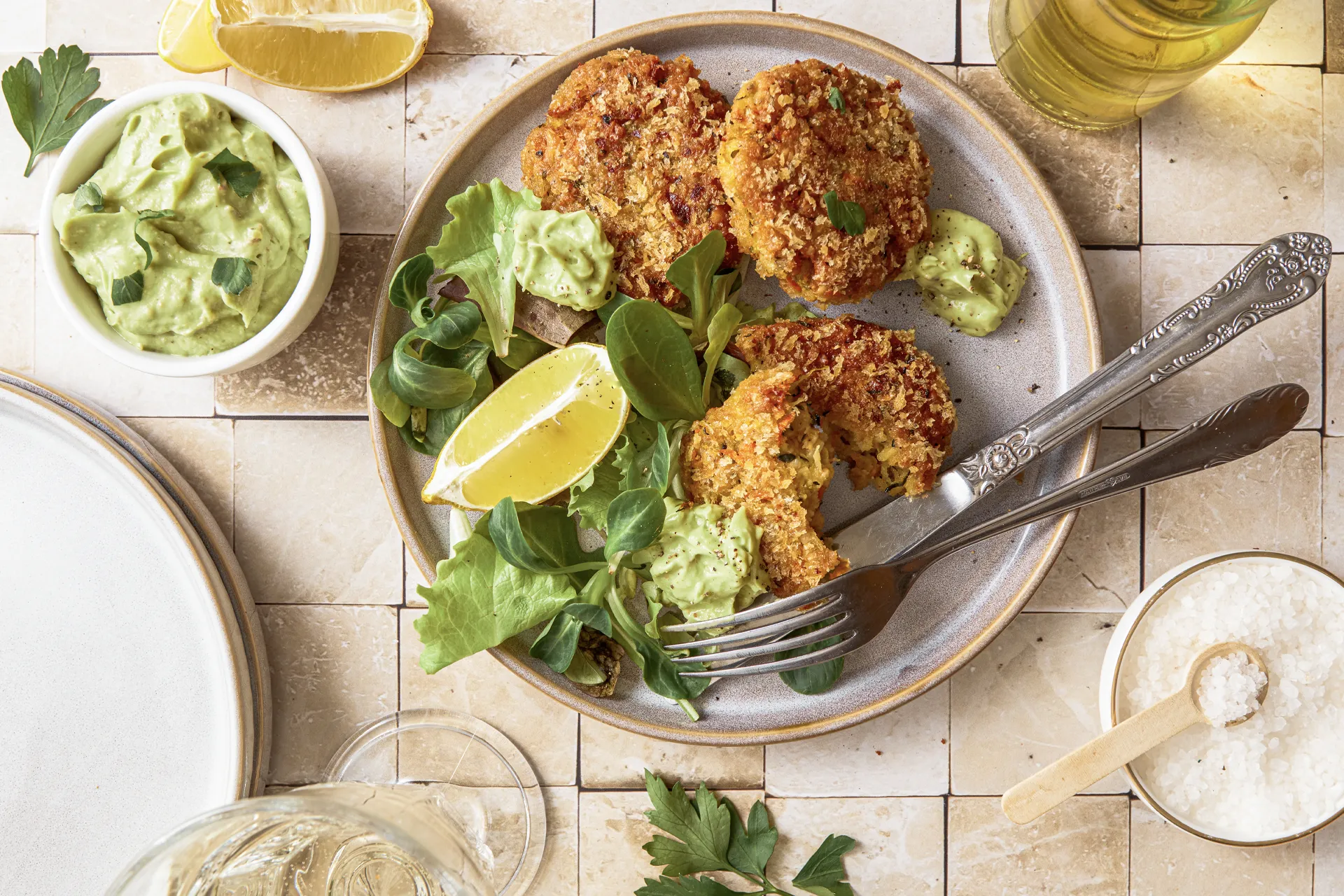 Gemüse-Bratlinge mit Avocado-Tahini-Dip, inspiriert von der Levante-Küche, serviert auf einem Teller mit frischen Kräutern und orientalischen Aromen.