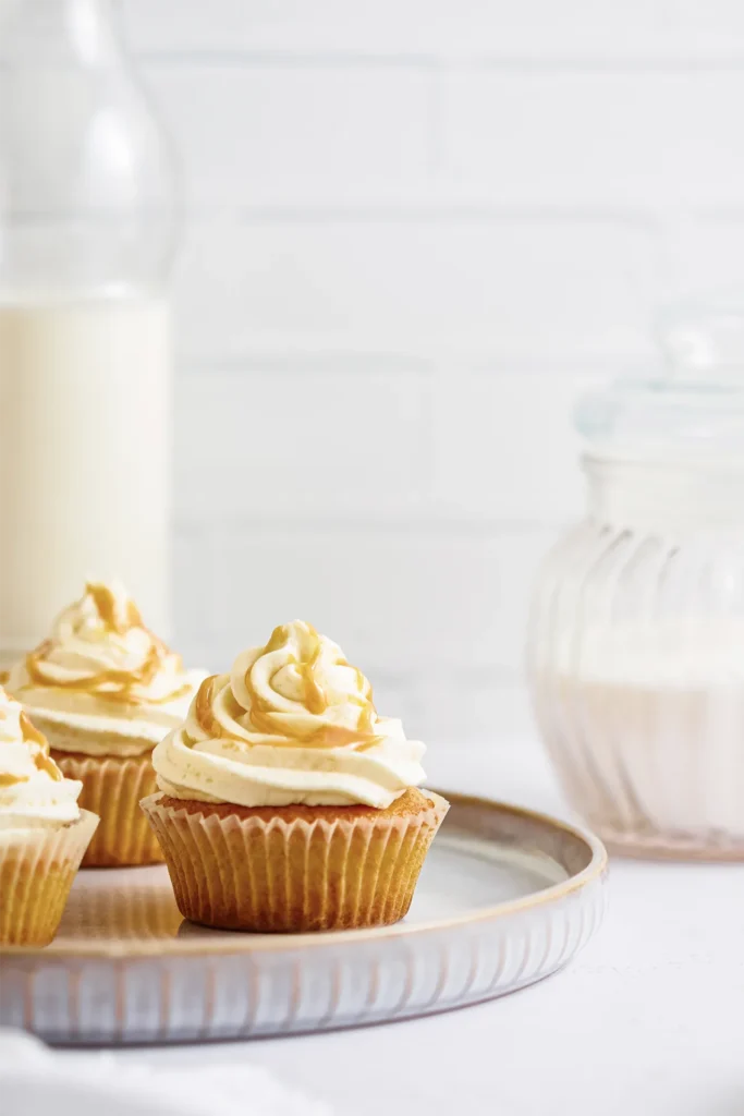 Karamell-Cupcakes mit cremigem Frosting, goldener Karamellsauce und dekorativen Topping