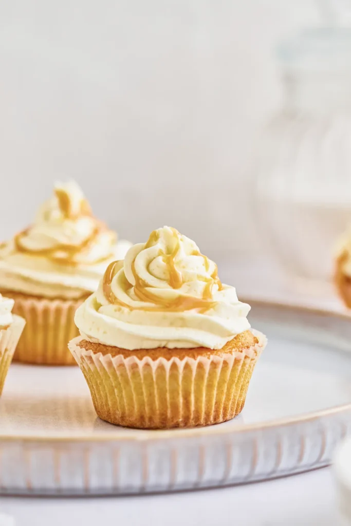 Karamell-Cupcakes mit cremigem Frosting, goldener Karamellsauce und dekorativen Topping