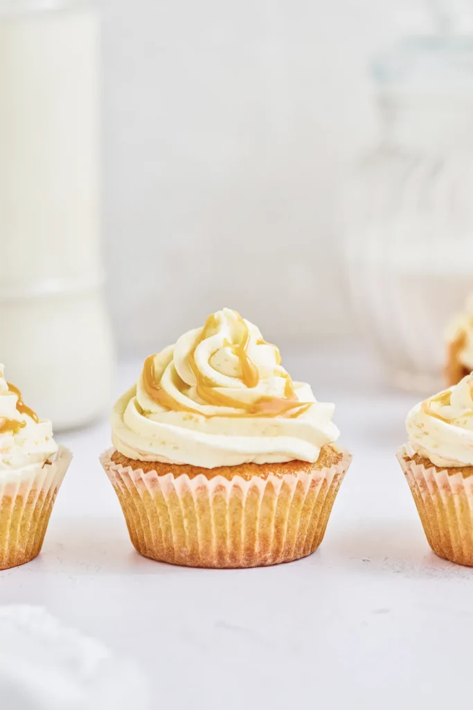 Karamell-Cupcakes mit cremigem Frosting, goldener Karamellsauce und dekorativen Topping