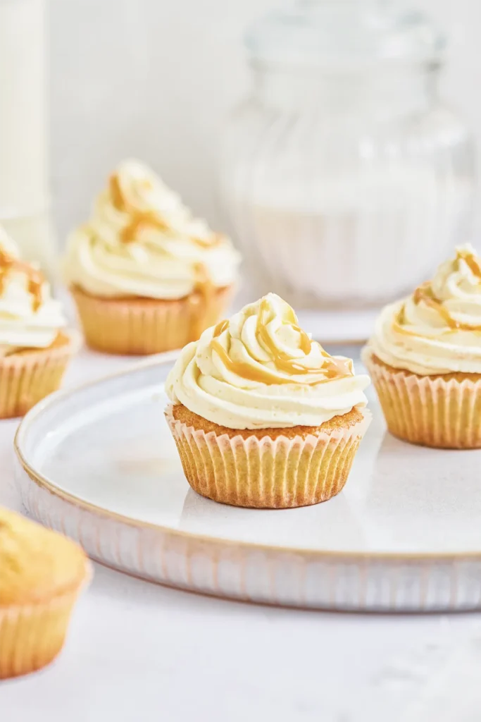 Karamell-Cupcakes mit cremigem Frosting, goldener Karamellsauce und dekorativen Topping