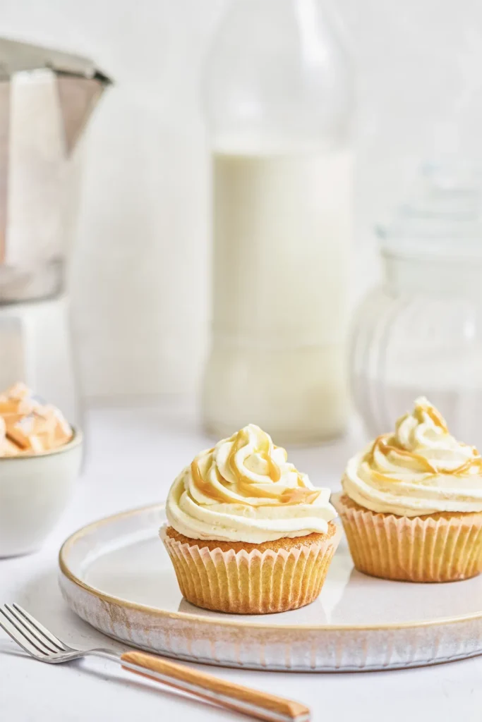 Karamell-Cupcakes mit cremigem Frosting, goldener Karamellsauce und dekorativen Topping