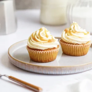 Karamell-Cupcakes mit cremigem Frosting, goldener Karamellsauce und dekorativen Topping