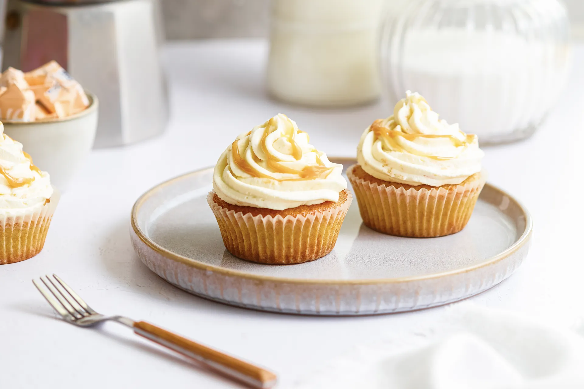 Karamell-Cupcakes mit cremigem Frosting, goldener Karamellsauce und dekorativen Topping