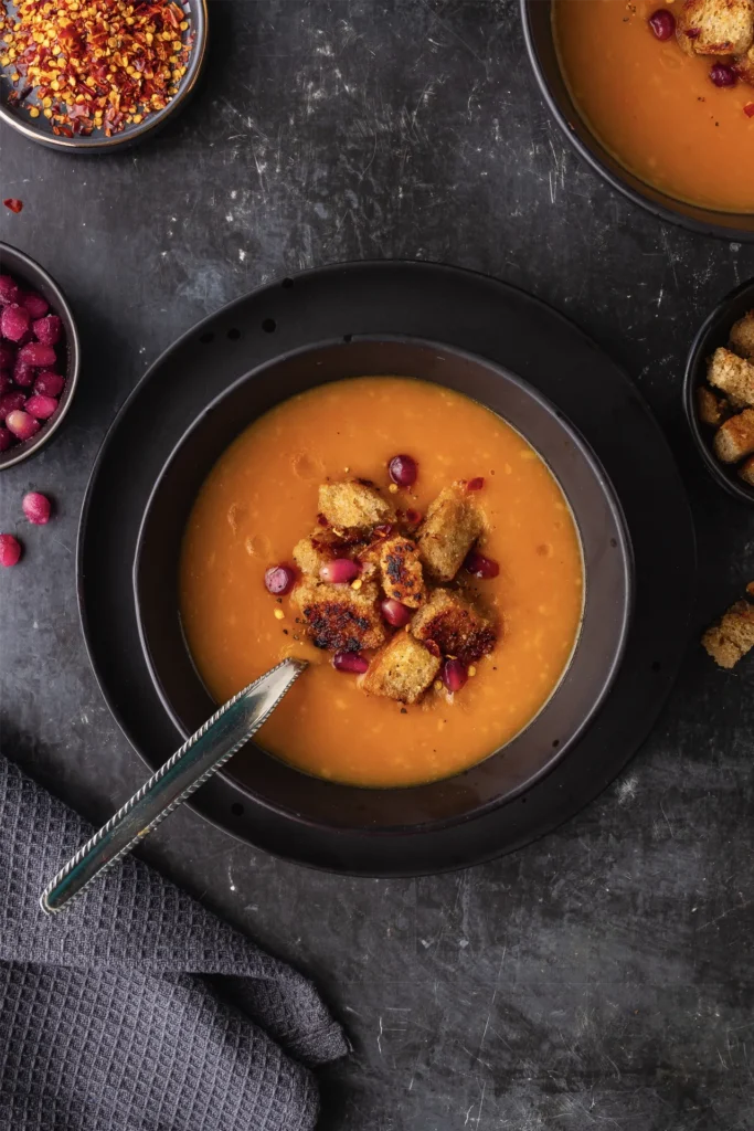 Wärmende Karotten-Ingwer-Suppe mit cremiger Kokosmilch, verfeinert mit frischen Kräutern – eine gesunde, aromatische Mahlzeit für kalte Tage.