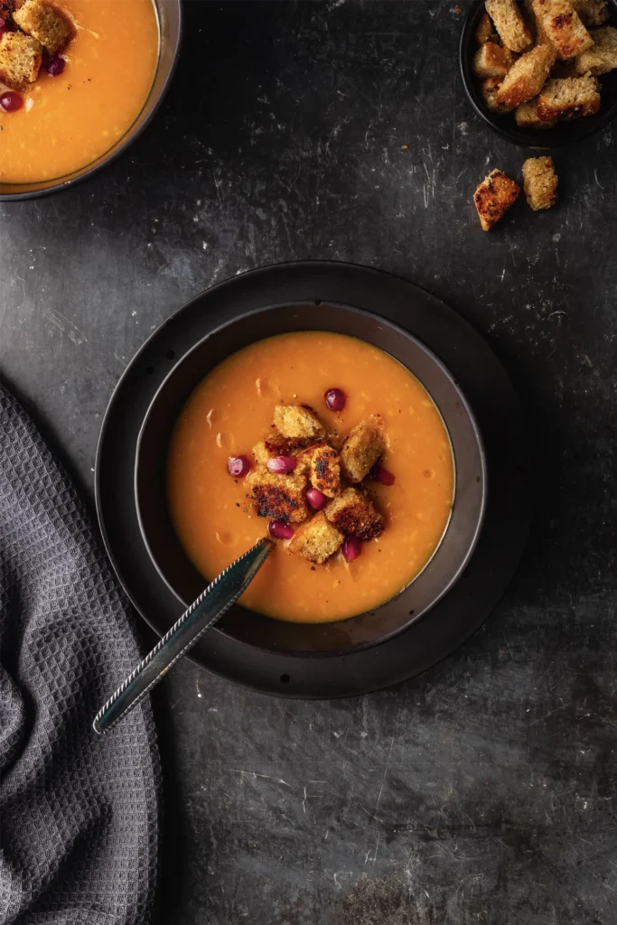 Wärmende Karotten-Ingwer-Suppe mit cremiger Kokosmilch, verfeinert mit frischen Kräutern – eine gesunde, aromatische Mahlzeit für kalte Tage.