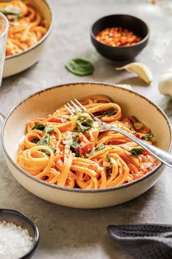 Linguine mit cremiger Frischkäse-Sauce, frischem Spinat und gehackten Tomaten – ein köstliches Pasta-Gericht für Genießer.