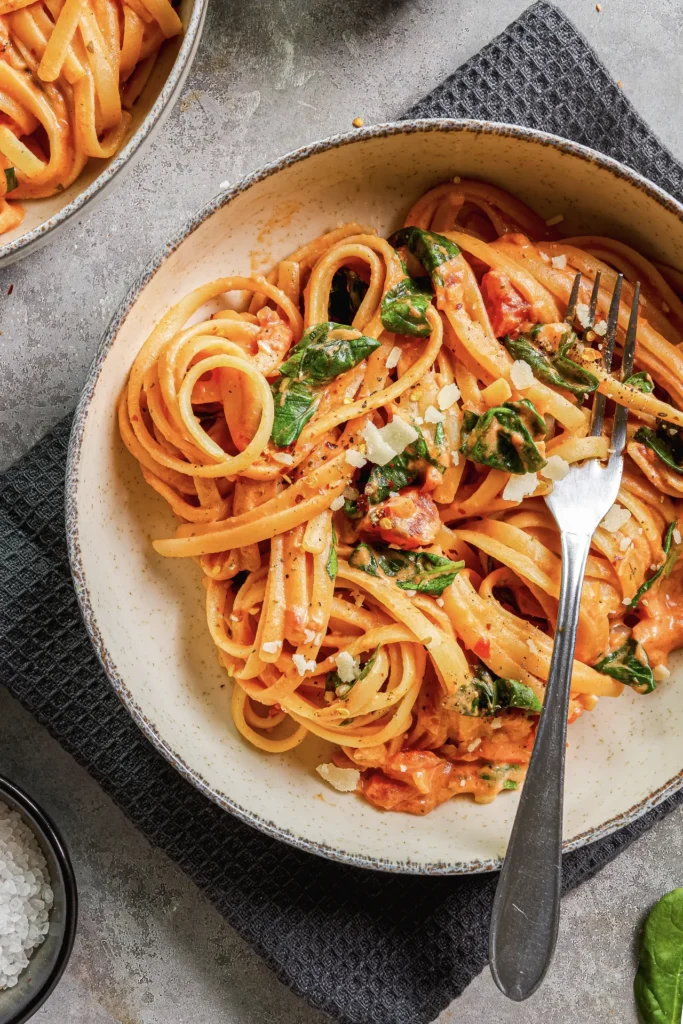 Linguine mit cremiger Frischkäse-Sauce, frischem Spinat und gehackten Tomaten – ein köstliches Pasta-Gericht für Genießer.