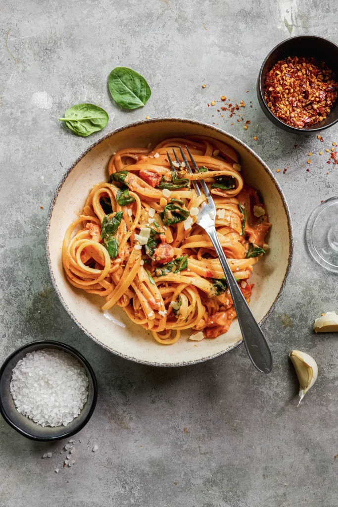 Linguine mit cremiger Frischkäse-Sauce, frischem Spinat und gehackten Tomaten – ein köstliches Pasta-Gericht für Genießer.