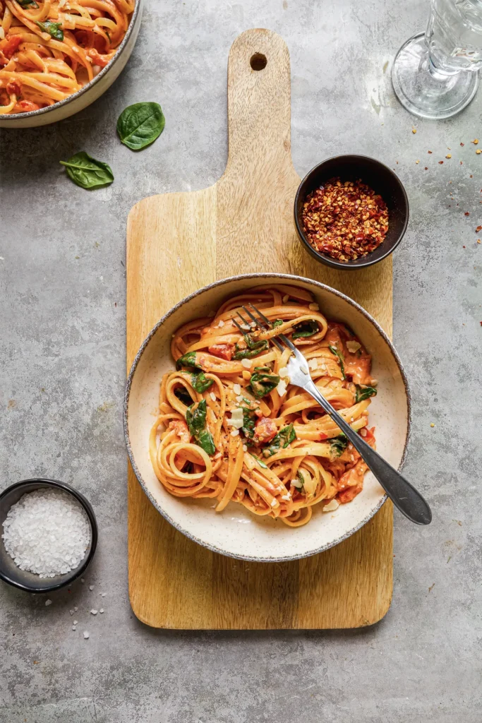 Linguine mit cremiger Frischkäse-Sauce, frischem Spinat und gehackten Tomaten – ein köstliches Pasta-Gericht für Genießer.