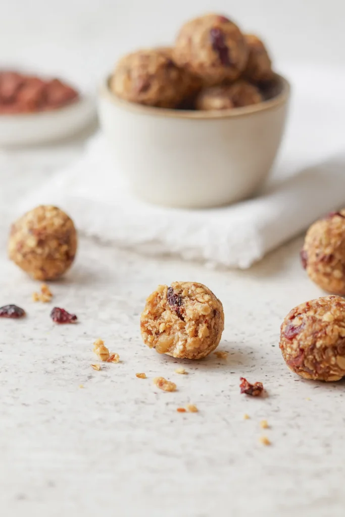 Gesunde Müsli-Bites mit Haferflocken, Leinsamen, Nüssen, Erdnussbutter und Honig auf einem rustikalen Holzbrett, idealer Snack für zwischendurch.