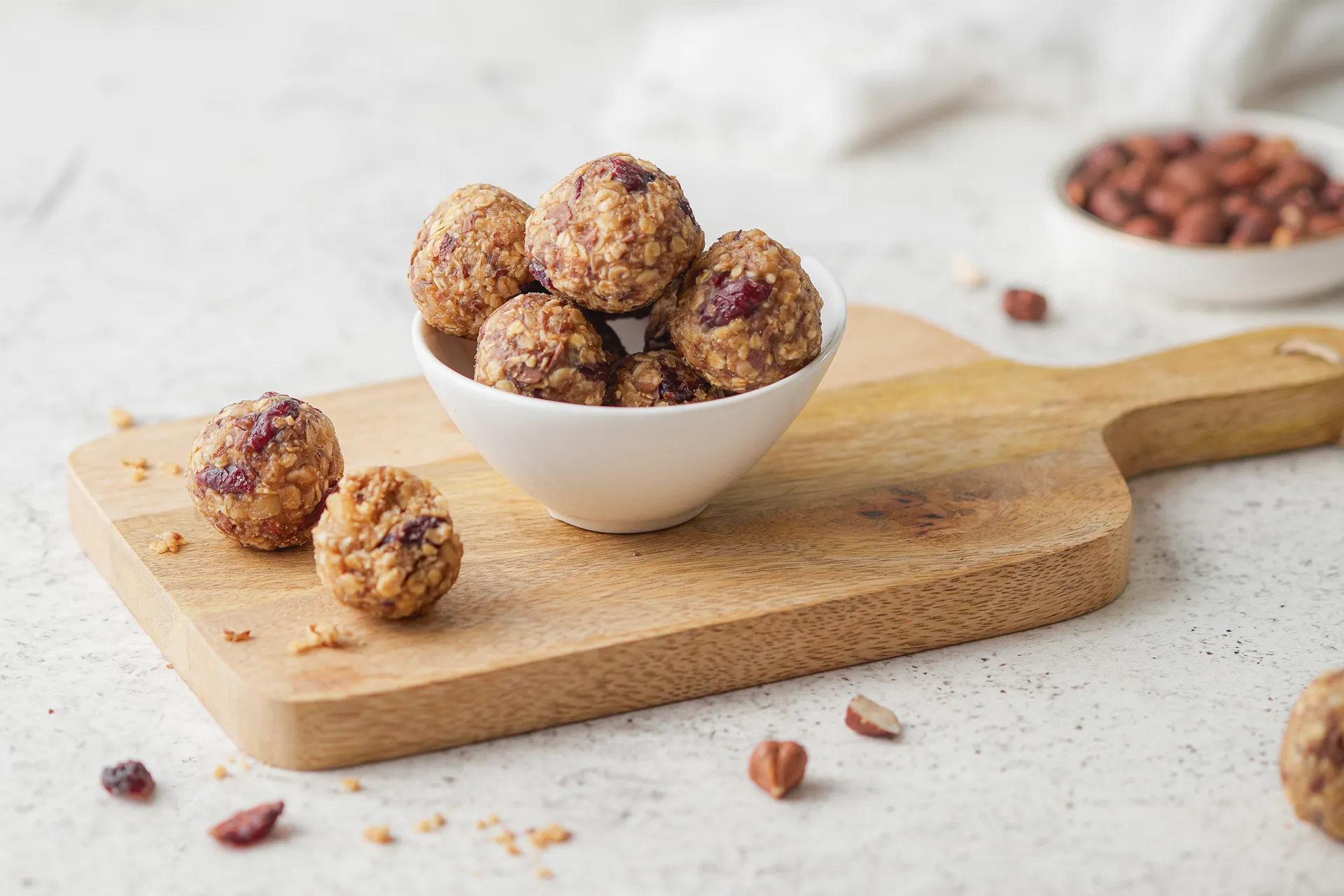 Gesunde Müsli-Bites mit Haferflocken, Leinsamen, Nüssen, Erdnussbutter und Honig auf einem rustikalen Holzbrett, idealer Snack für zwischendurch.