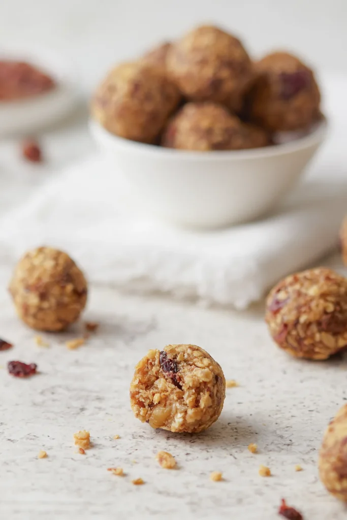 Gesunde Müsli-Bites mit Haferflocken, Leinsamen, Nüssen, Erdnussbutter und Honig auf einem rustikalen Holzbrett, idealer Snack für zwischendurch.