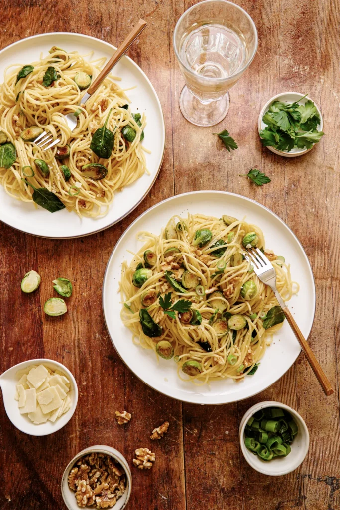 „Spaghetti mit Rosenkohl, Walnüssen und Spinat – winterliches Pastagericht mit knackigem Gemüse, nussiger Note und frischem Spinat auf rustikalem Teller.“