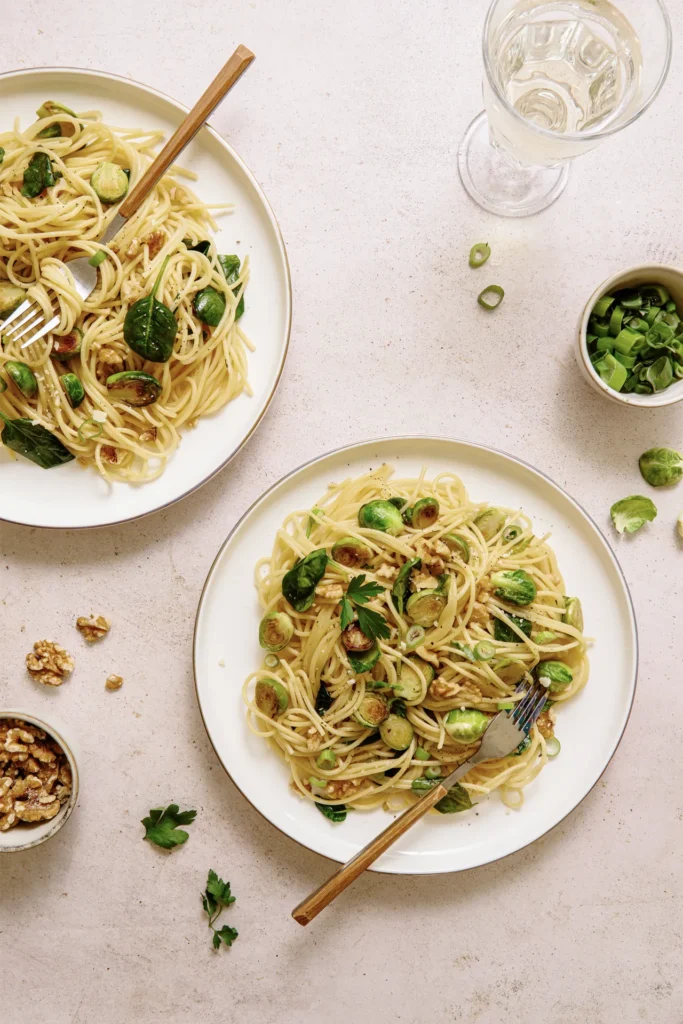 „Spaghetti mit Rosenkohl, Walnüssen und Spinat – winterliches Pastagericht mit knackigem Gemüse, nussiger Note und frischem Spinat auf rustikalem Teller.“