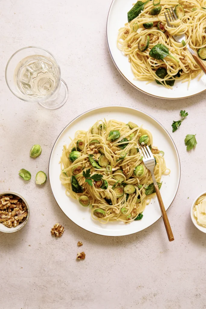 „Spaghetti mit Rosenkohl, Walnüssen und Spinat – winterliches Pastagericht mit knackigem Gemüse, nussiger Note und frischem Spinat auf rustikalem Teller.“