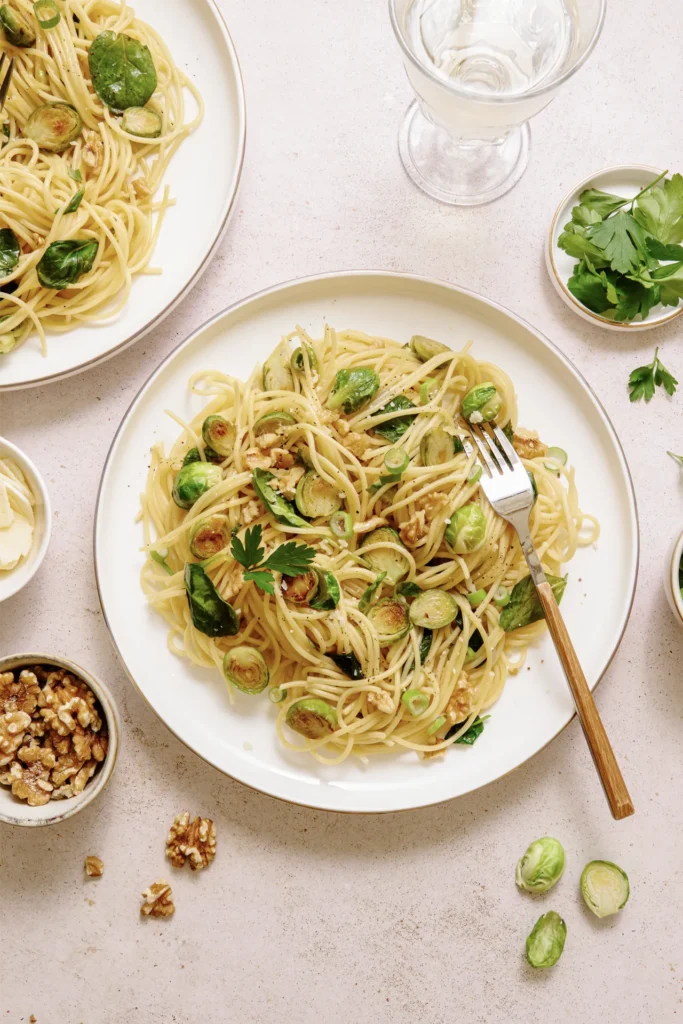 „Spaghetti mit Rosenkohl, Walnüssen und Spinat – winterliches Pastagericht mit knackigem Gemüse, nussiger Note und frischem Spinat auf rustikalem Teller.“