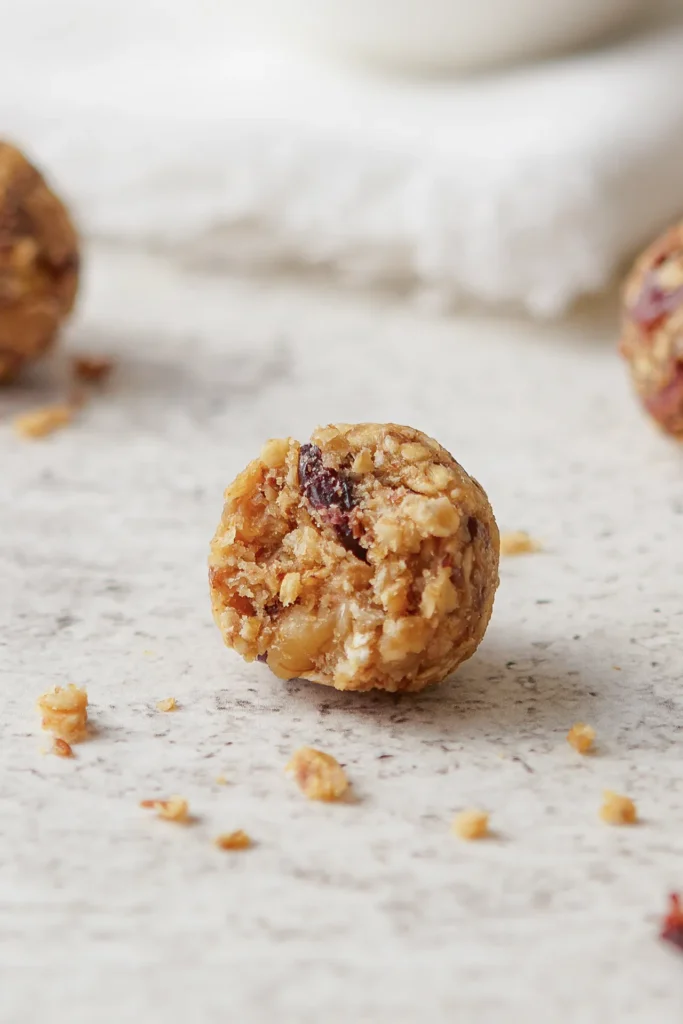 Gesunde Müsli-Bites mit Haferflocken, Leinsamen, Nüssen, Erdnussbutter und Honig auf einem rustikalen Holzbrett, idealer Snack für zwischendurch.