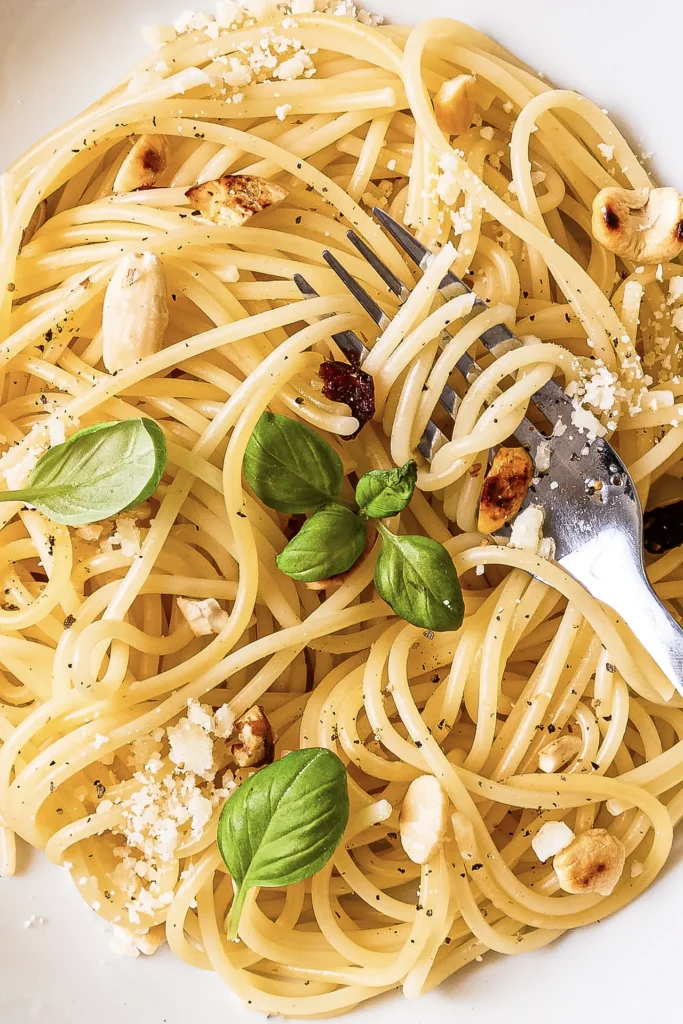 Ein Teller Zitronen-Pasta mit frischem Basilikum, Parmesan und einer Zitronenscheibe