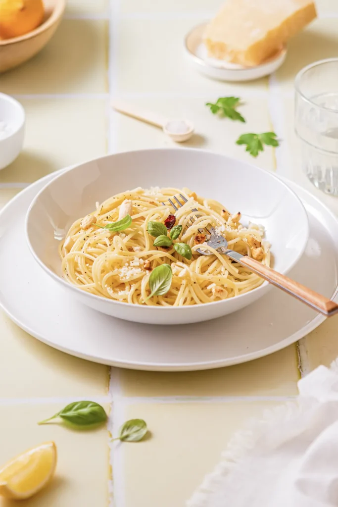 Ein Teller Zitronen-Pasta mit frischem Basilikum, Parmesan und einer Zitronenscheibe