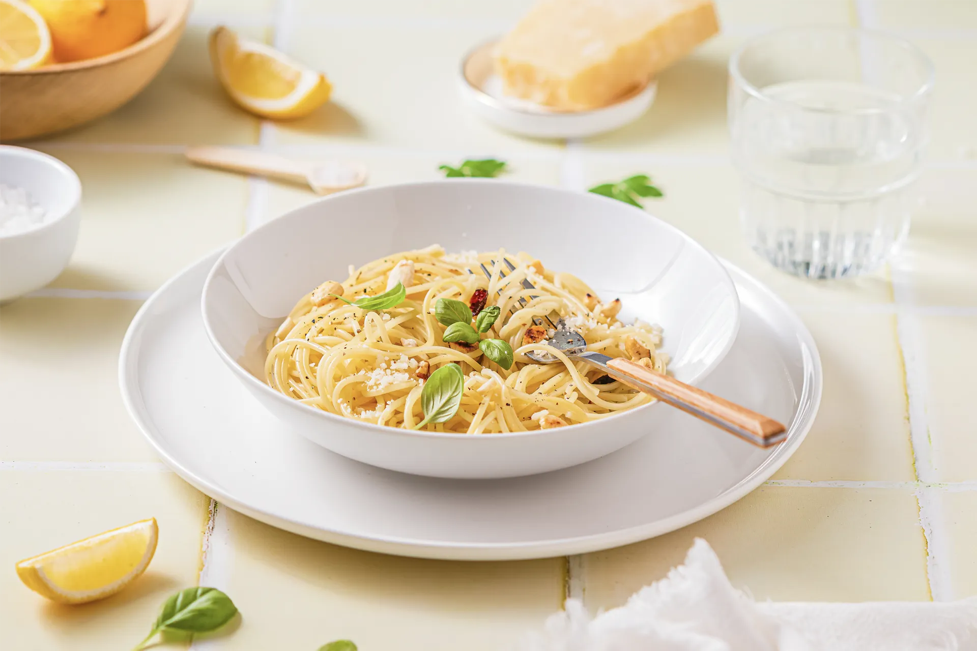 Ein Teller Zitronen-Pasta mit frischem Basilikum, Parmesan und einer Zitronenscheibe